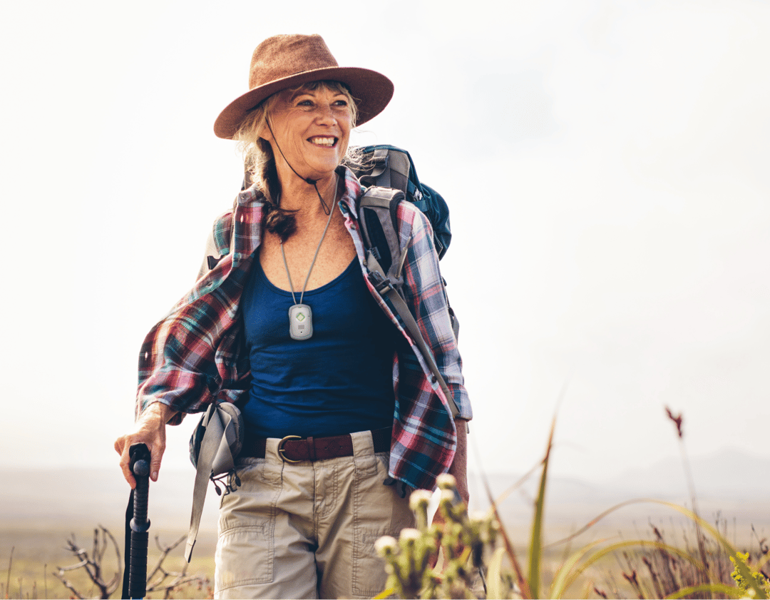 Senior woman hiking with a personal emergency response system around her neck